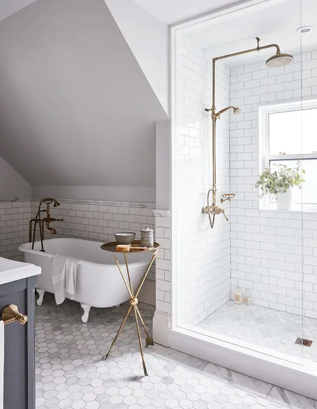 Bathroom with marble floor tile, white subway tile and brass accents - That Homebird Life Blog
