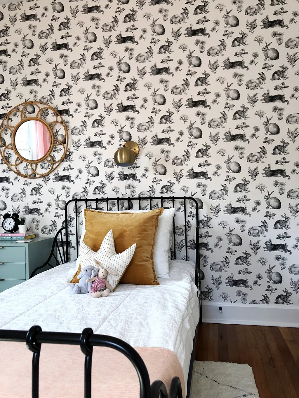 twin bed with white bedding and rabbit wallpaper