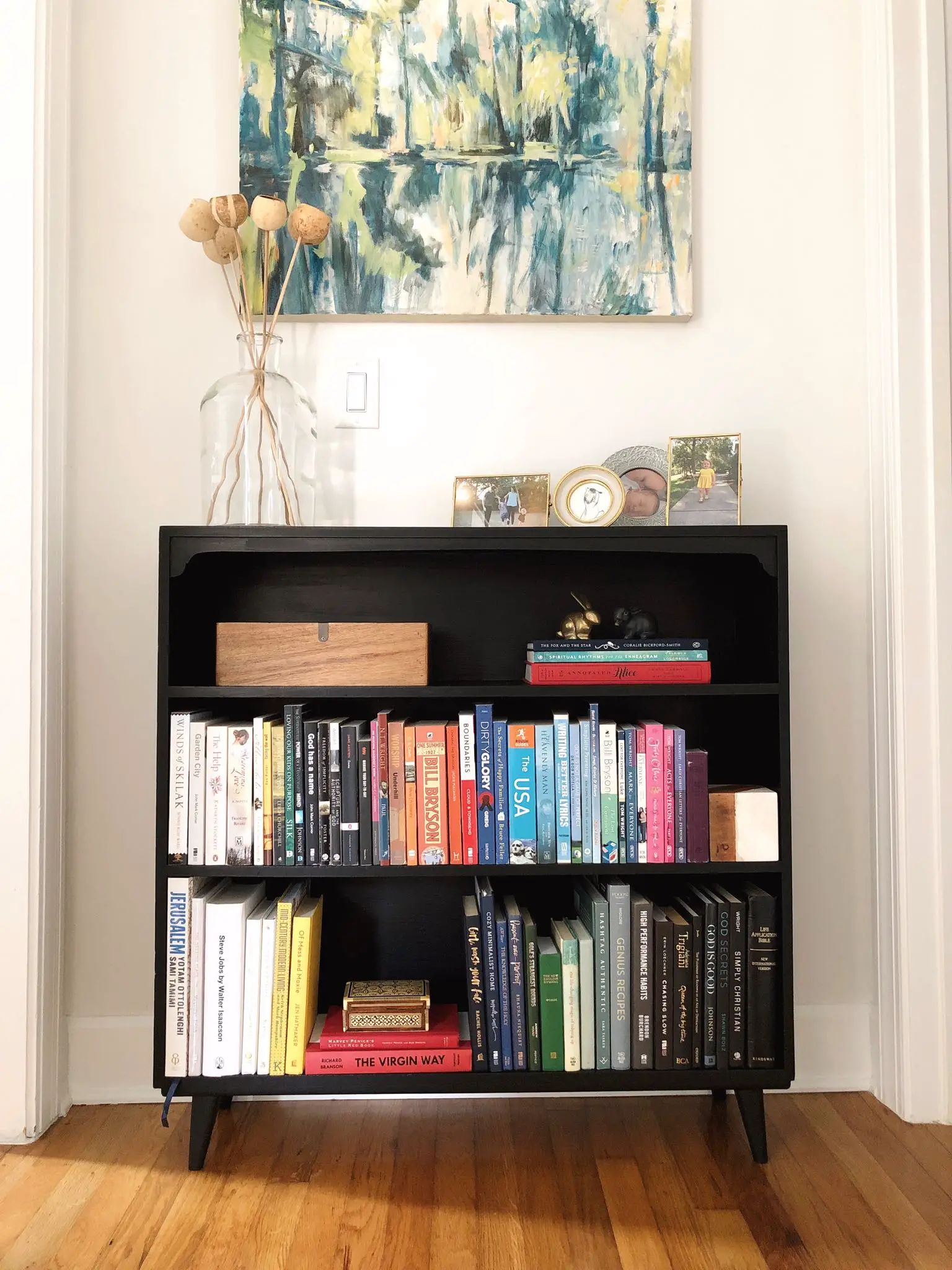 black bookcase with books arranged by color