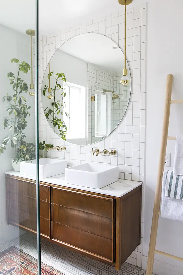 Bathroom with white hex floor tile, white subway tile, antique wooden vanity and brass accents - That Homebird Life Blog