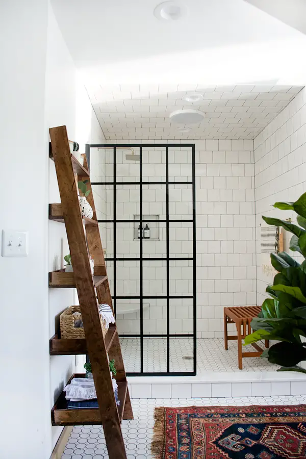 Bathroom with white hex floor tile, white square subway tile, brass accents and vintage rug - That Homebird Life Blog