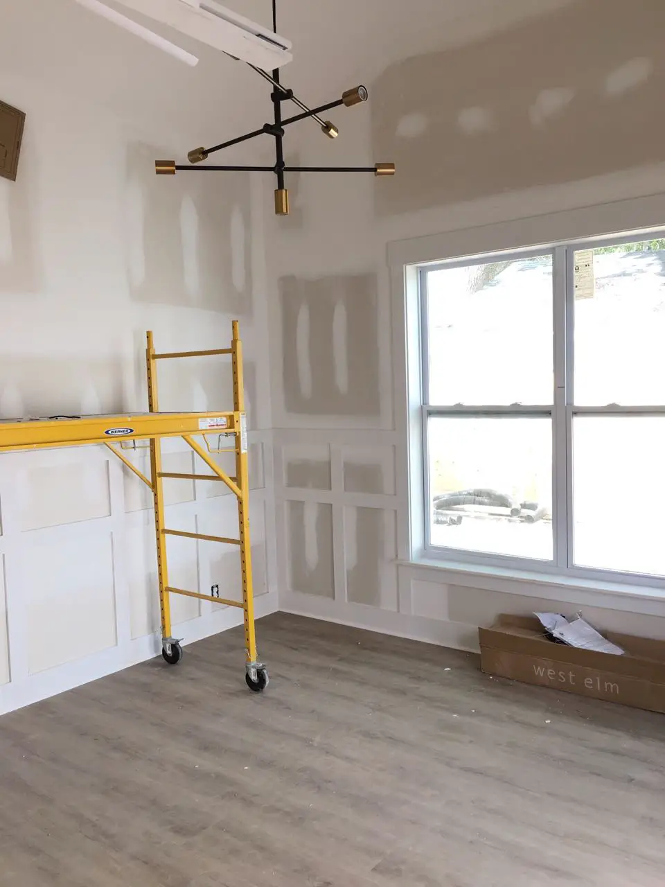 Guest house in progress with paneling and modern chandelier - That Homebird Life Blog