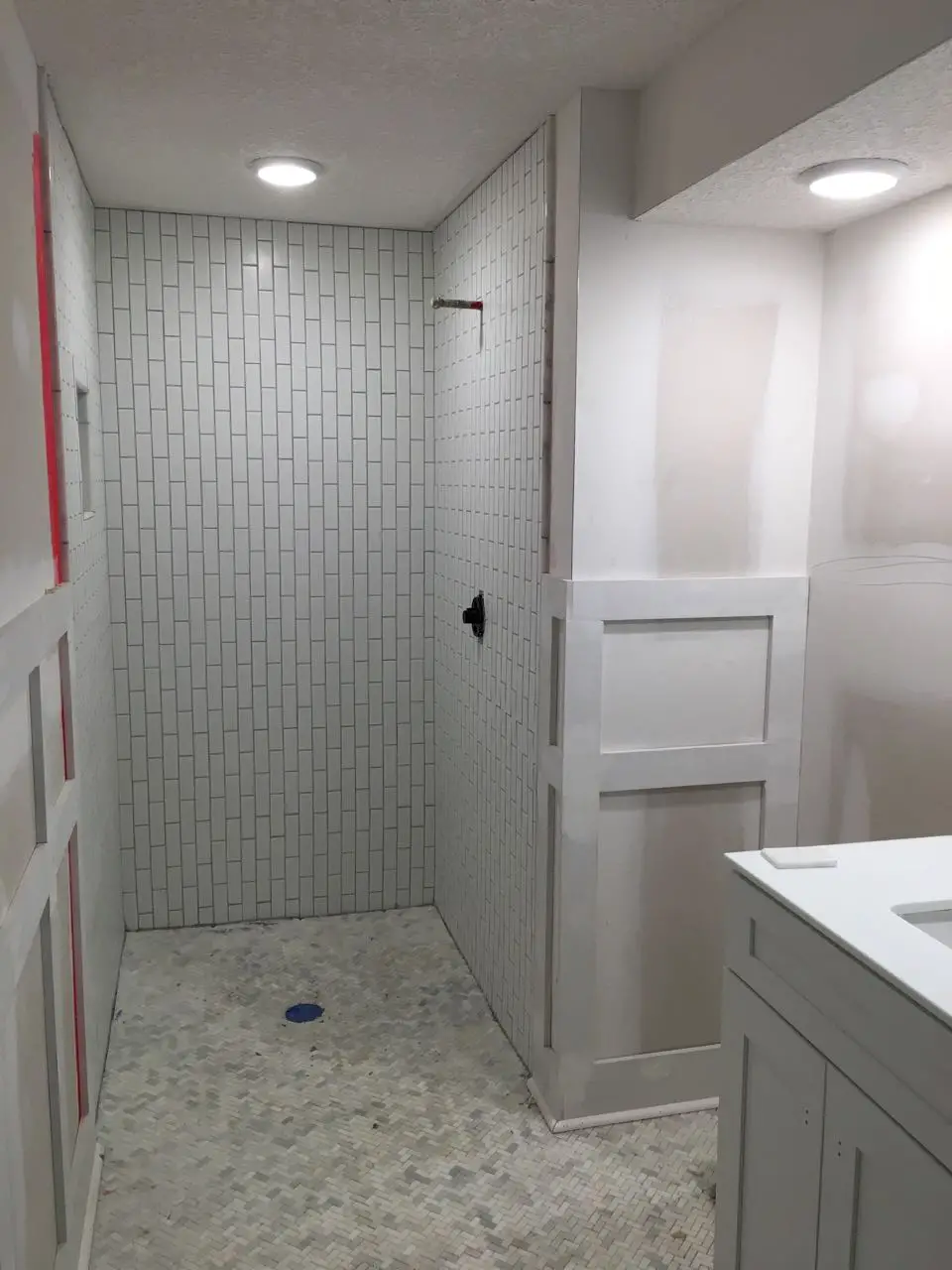 Marble herringbone tile bathroom floor with vertical subway shower surround - That Homebird Life Blog