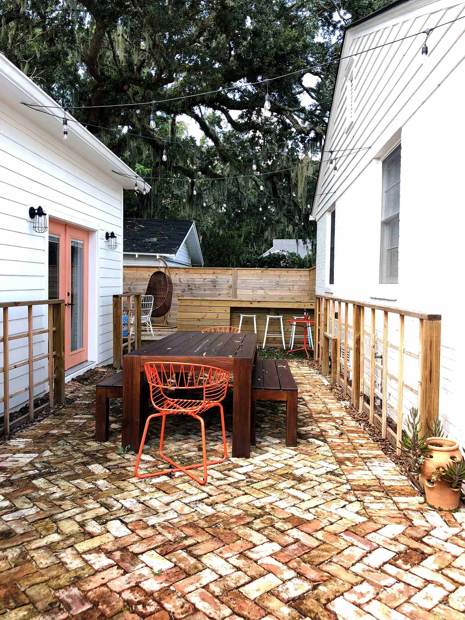 Current situation - dining area, string lights, reclaimed brick paver patio in herringbone pattern - That Homebird Life Blog