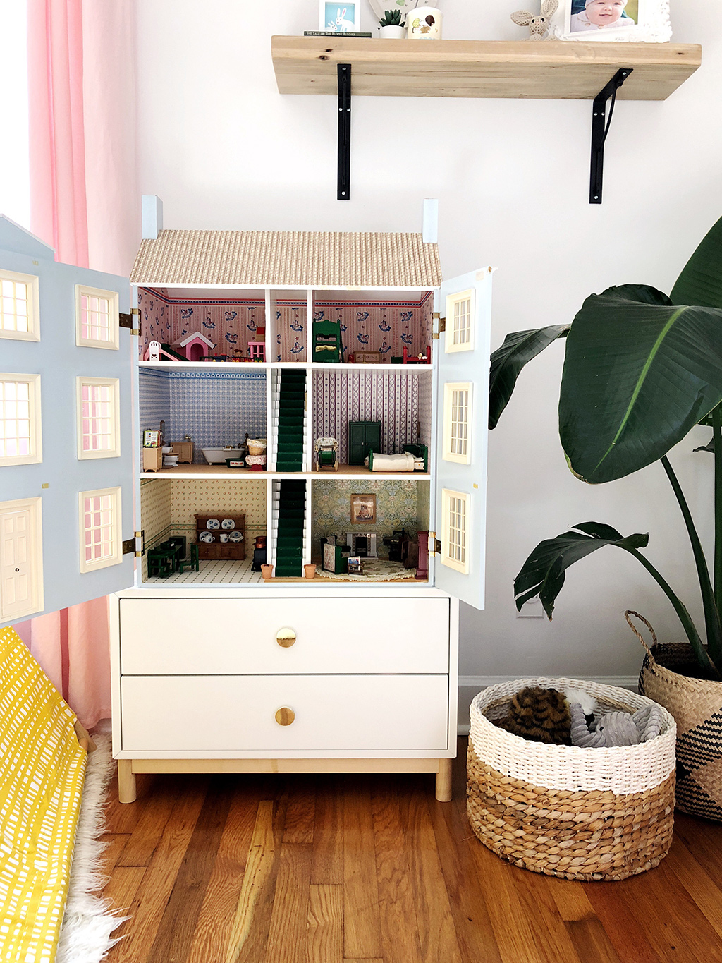 blue doll house in corner of girls bedroom