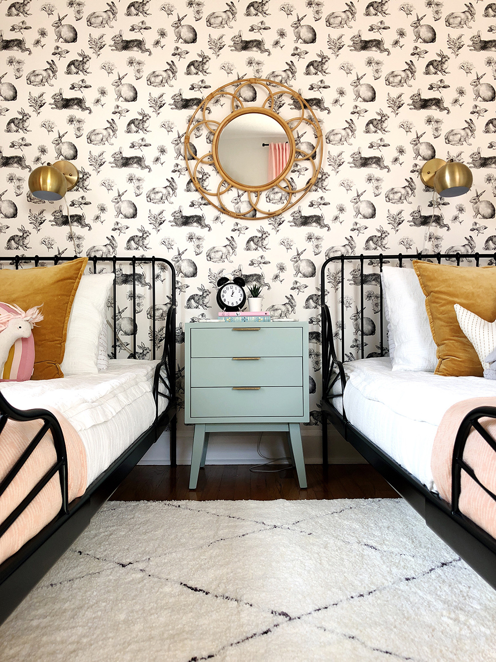 shared girls' bedroom with twin beds and rabbit wallpaper