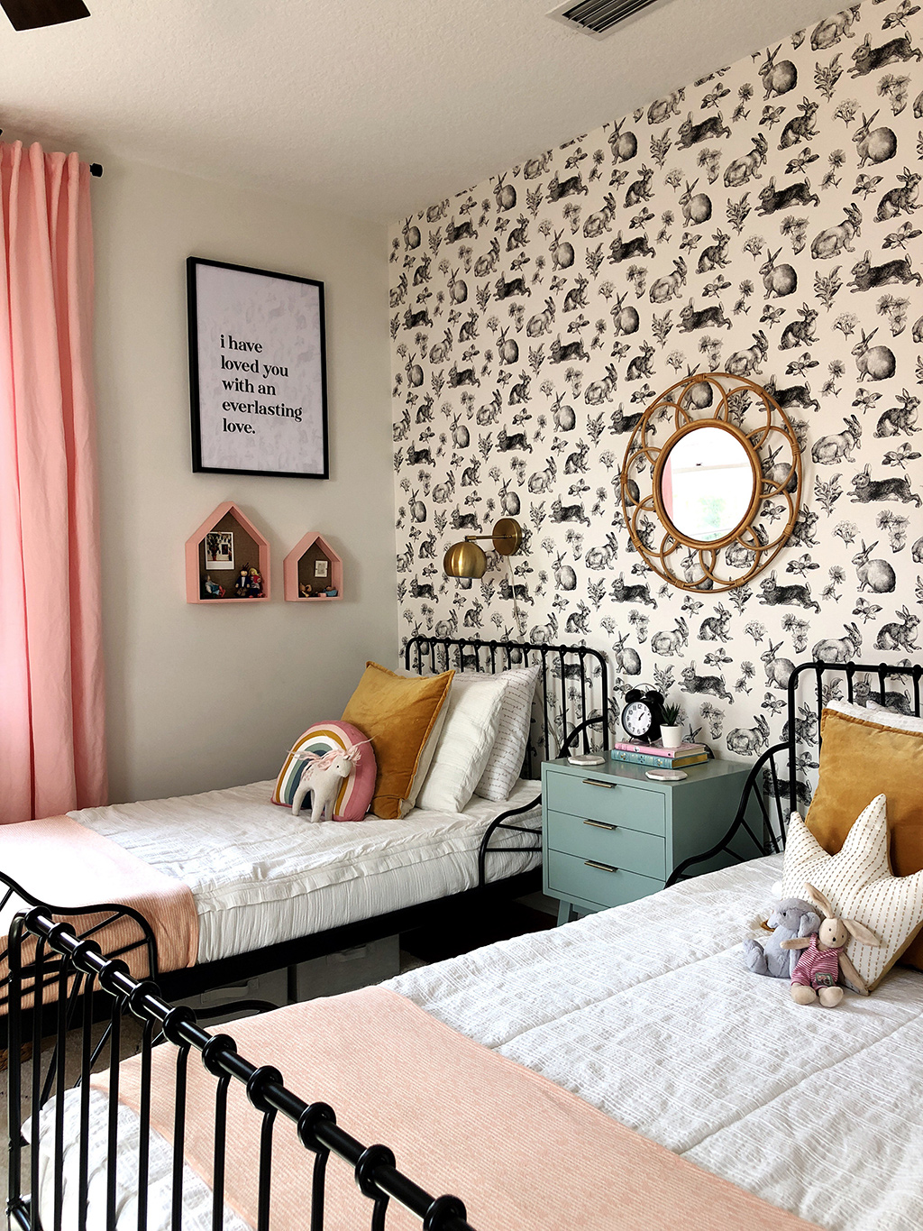 twin beds with white bedding and rabbit wallpaper