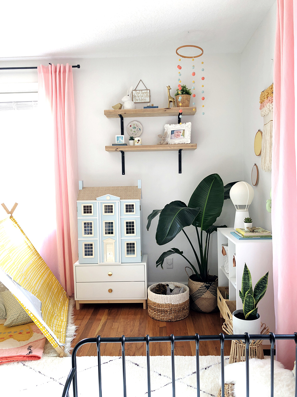 blue doll house in corner of girls bedroom