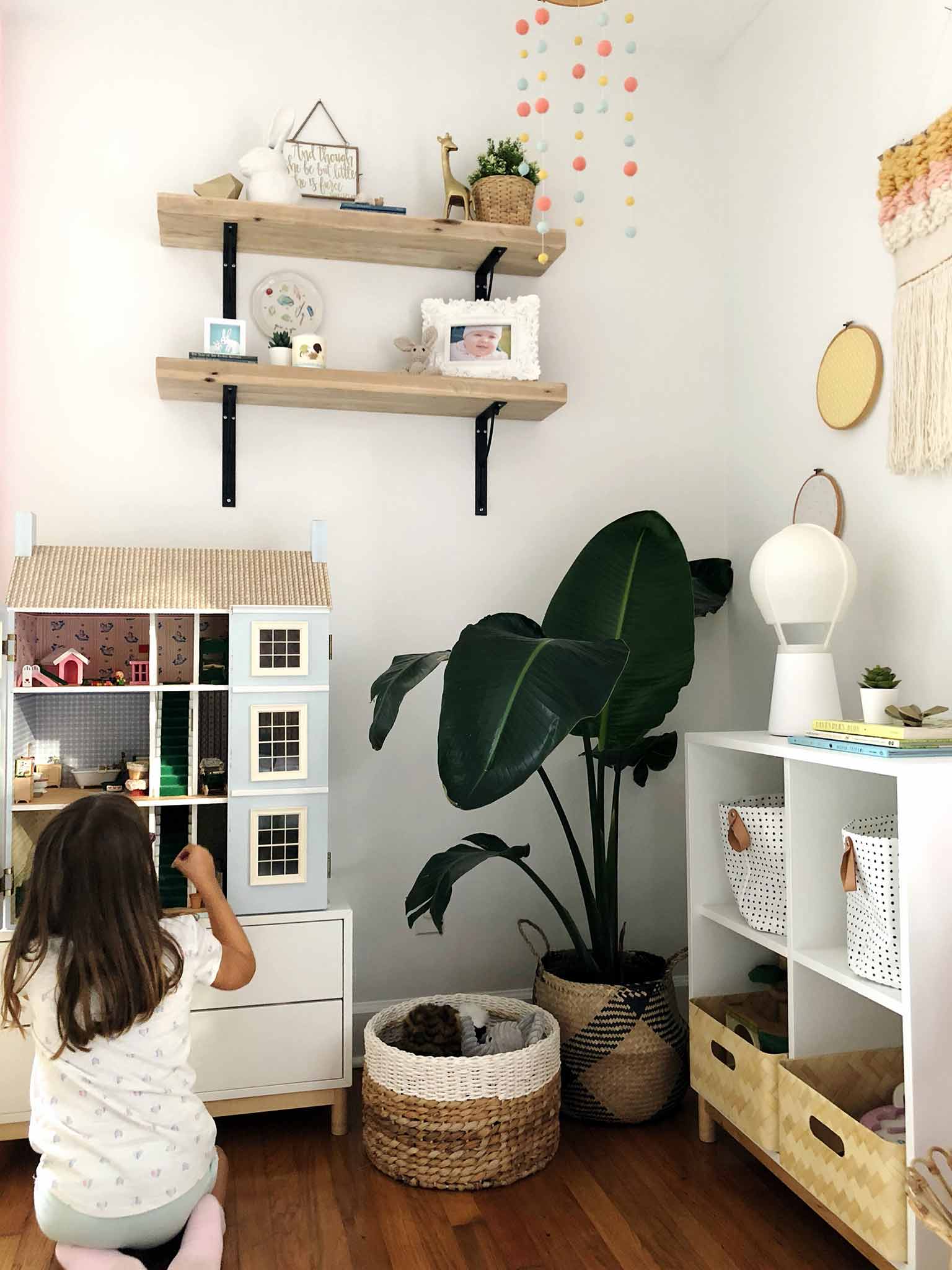 blue doll house in corner of girls bedroom