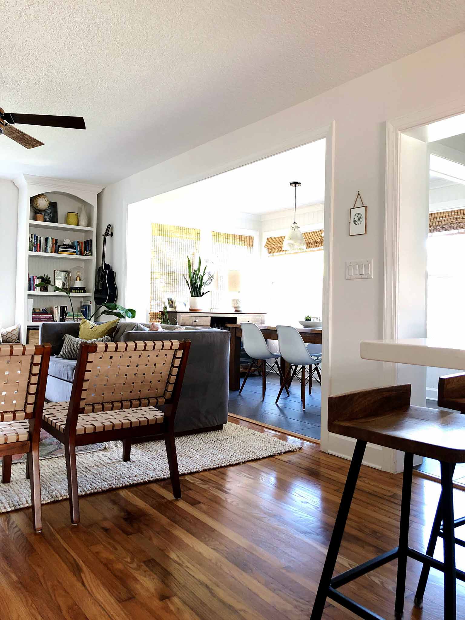 Open concept living room and dining room with hardwood floors and white walls