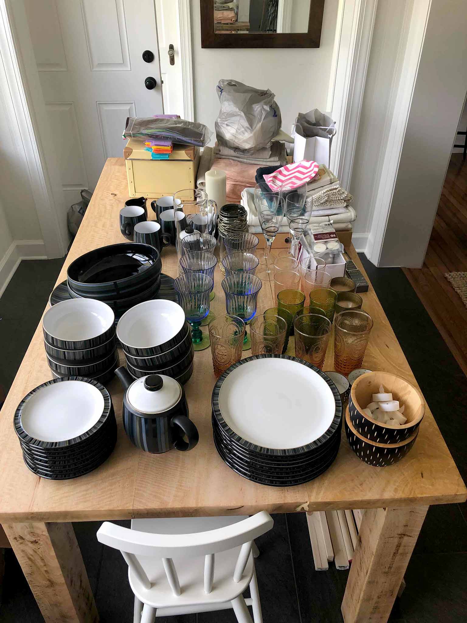 Dining table piled with glassware and dishes