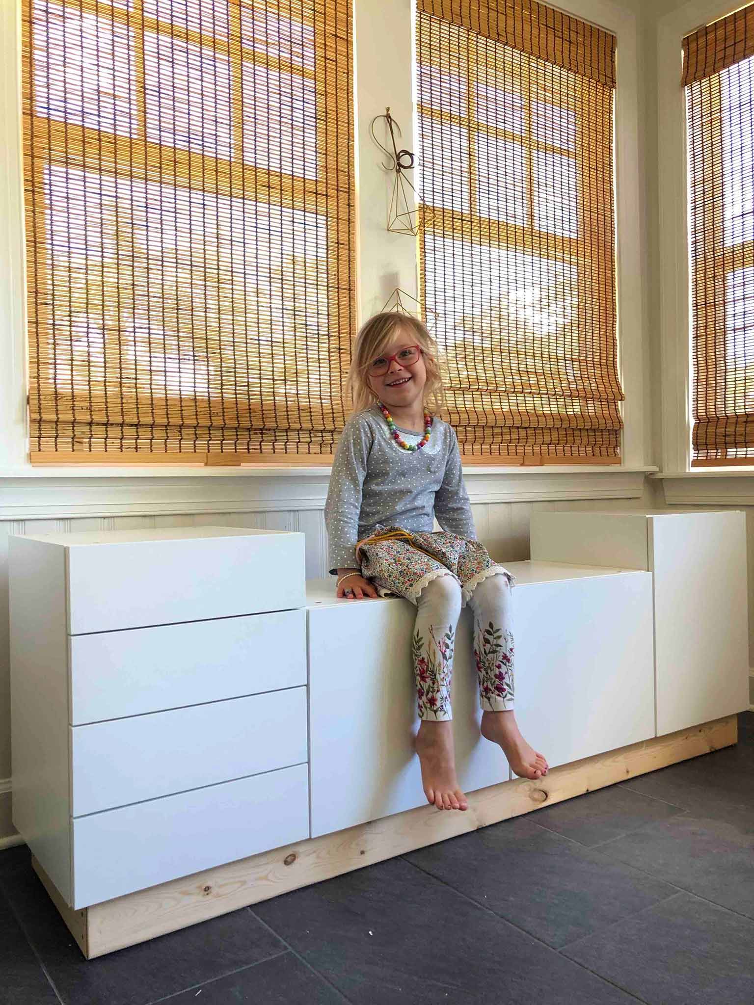 girl sitting on window bench