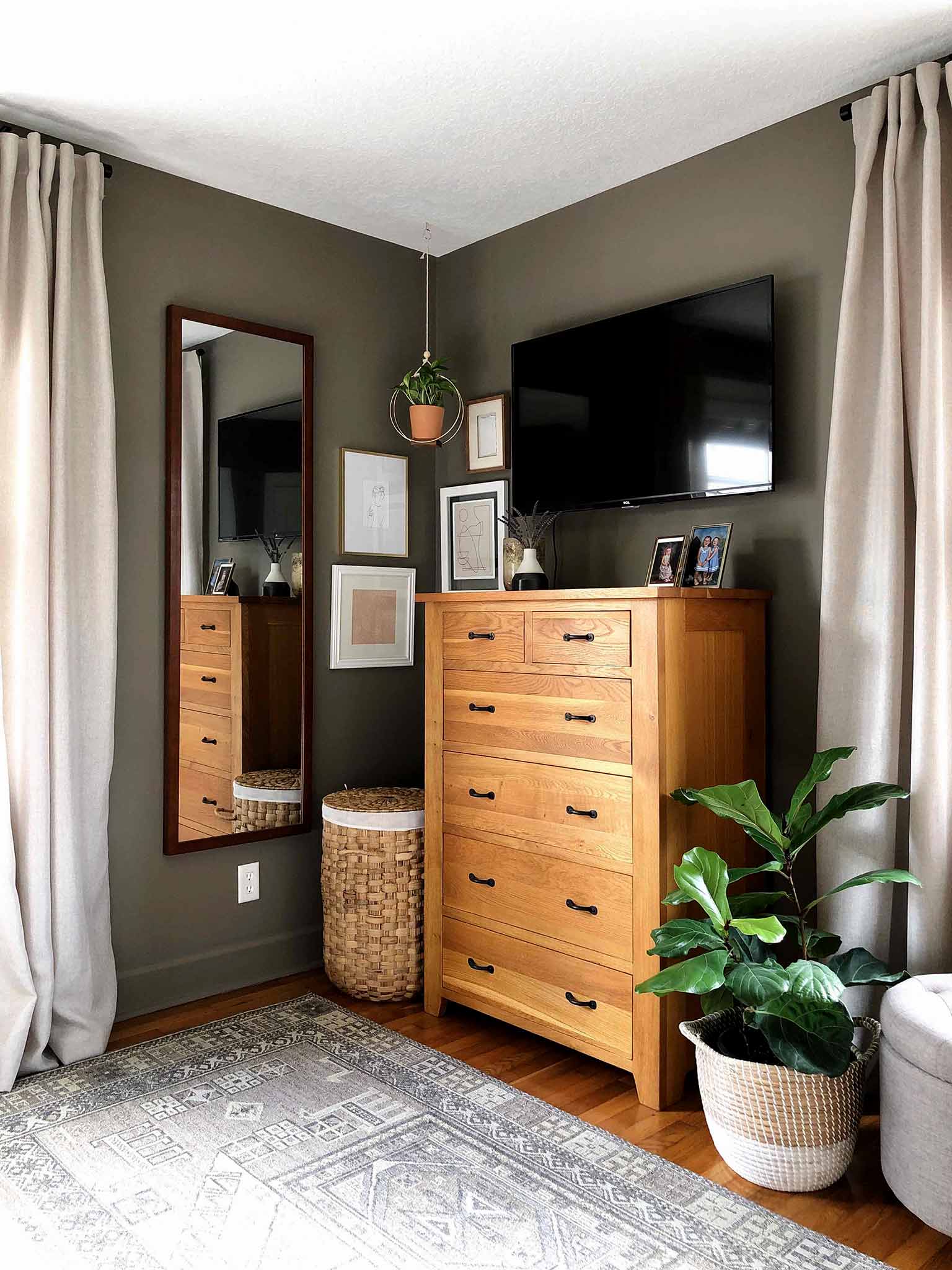 view of master bedroom dresser, mirror and plant