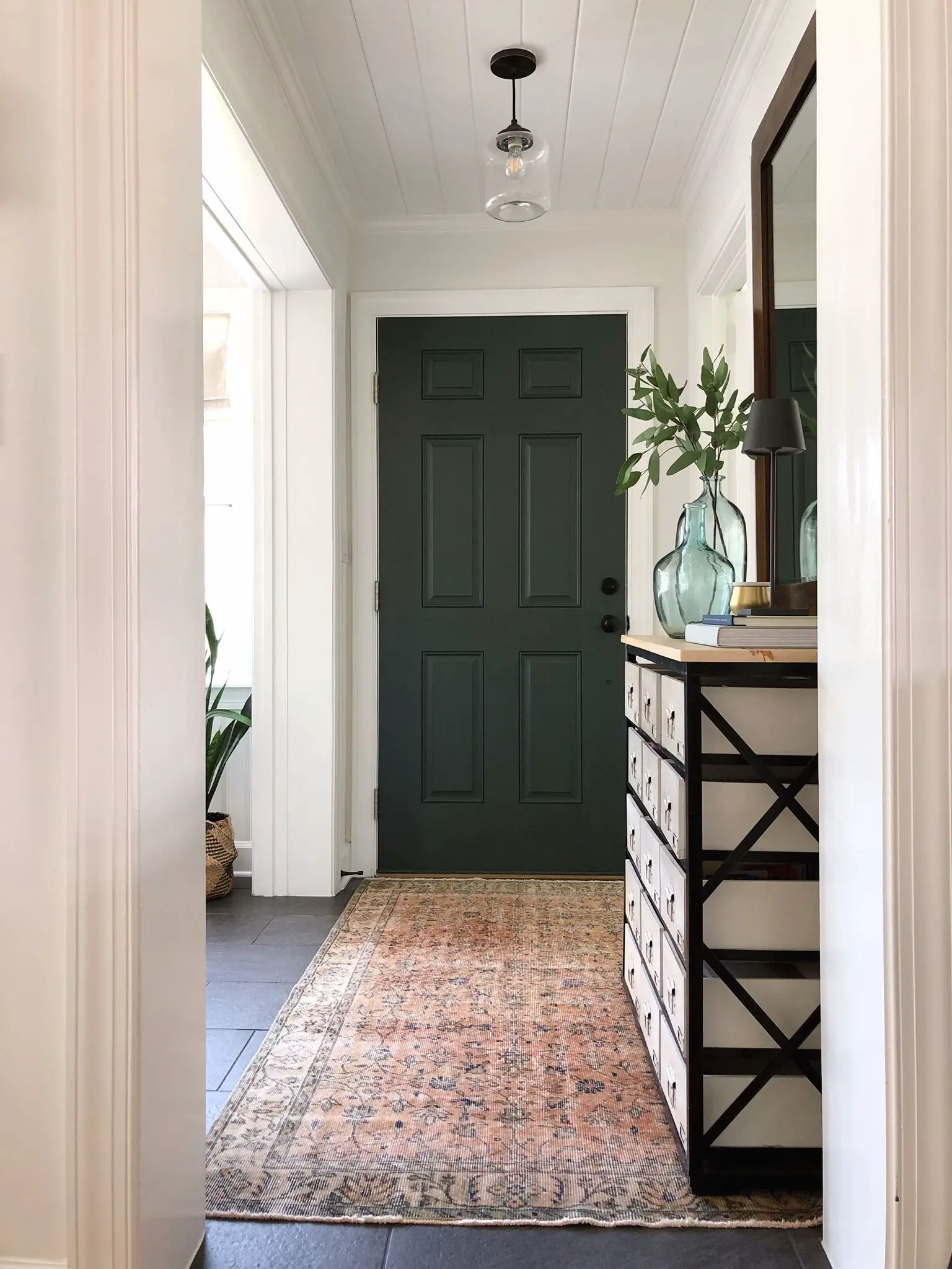 entryway with green door and vintage rug