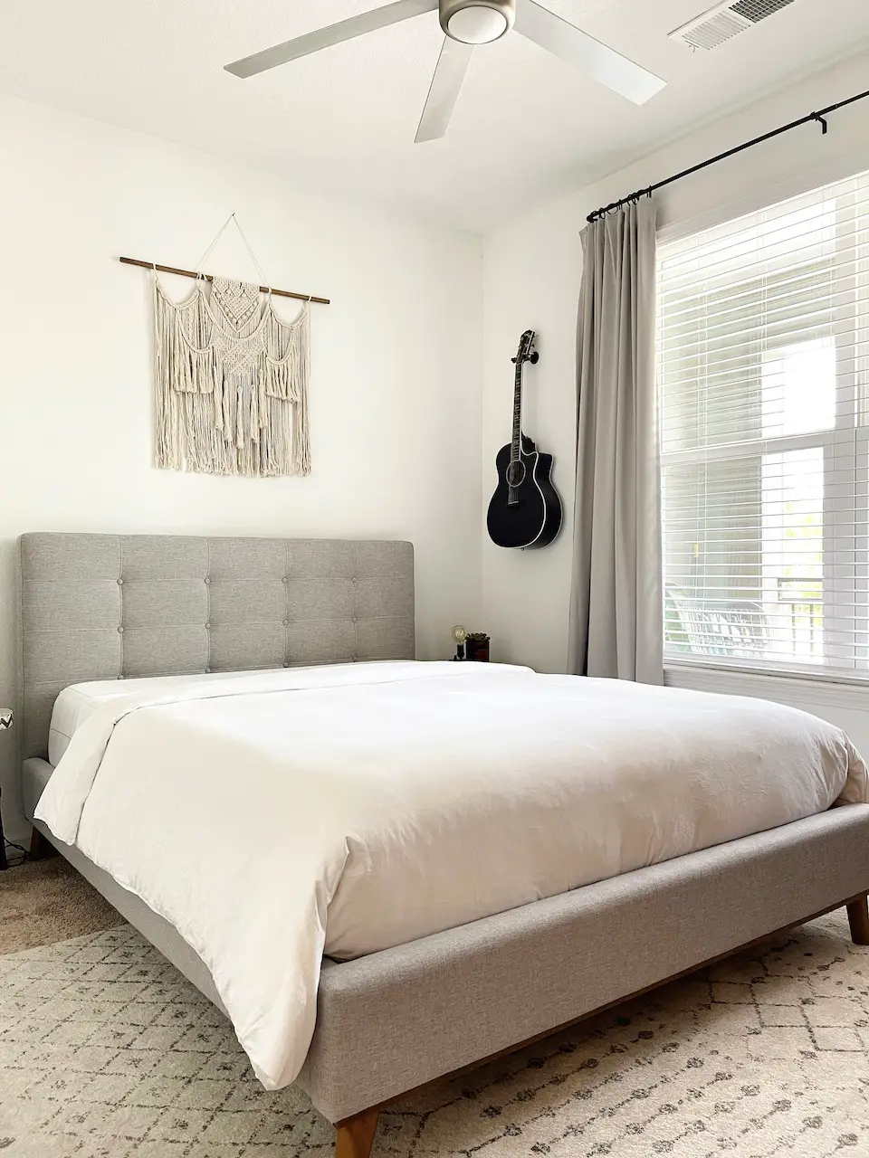 bedroom with queen bed and guitar on the wall