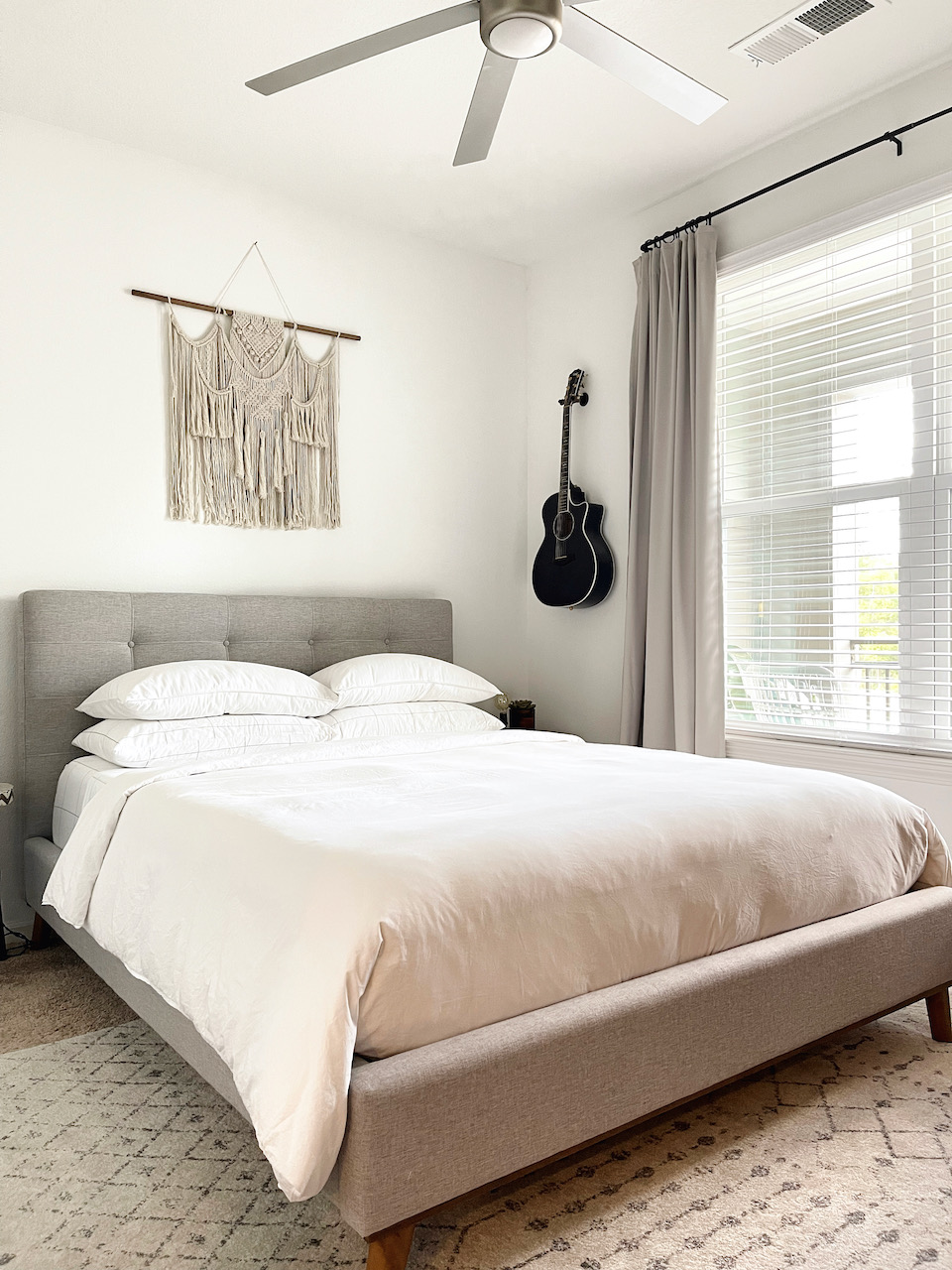 bedroom with queen bed and guitar on the wall