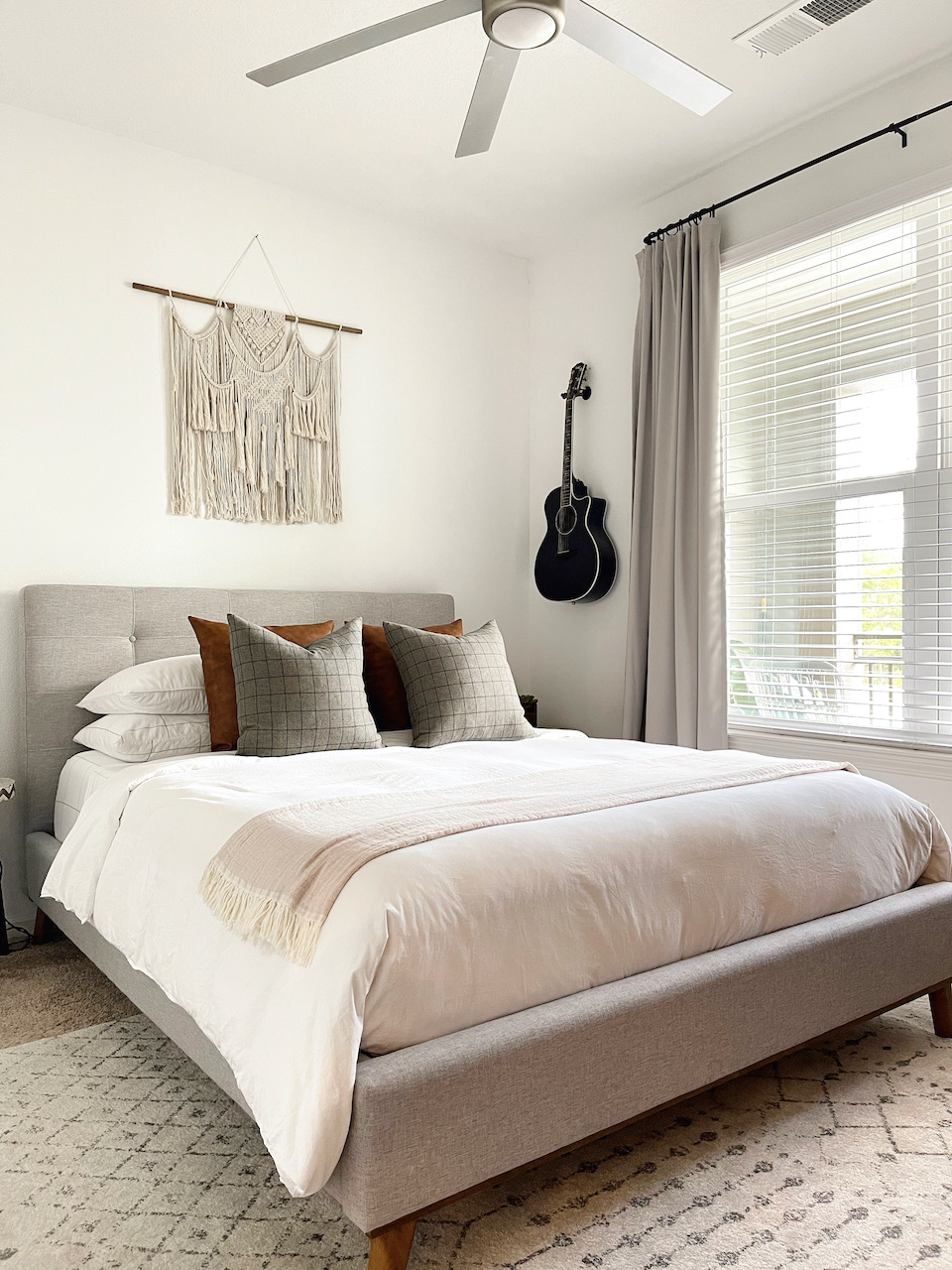 bedroom with queen bed and guitar on the wall