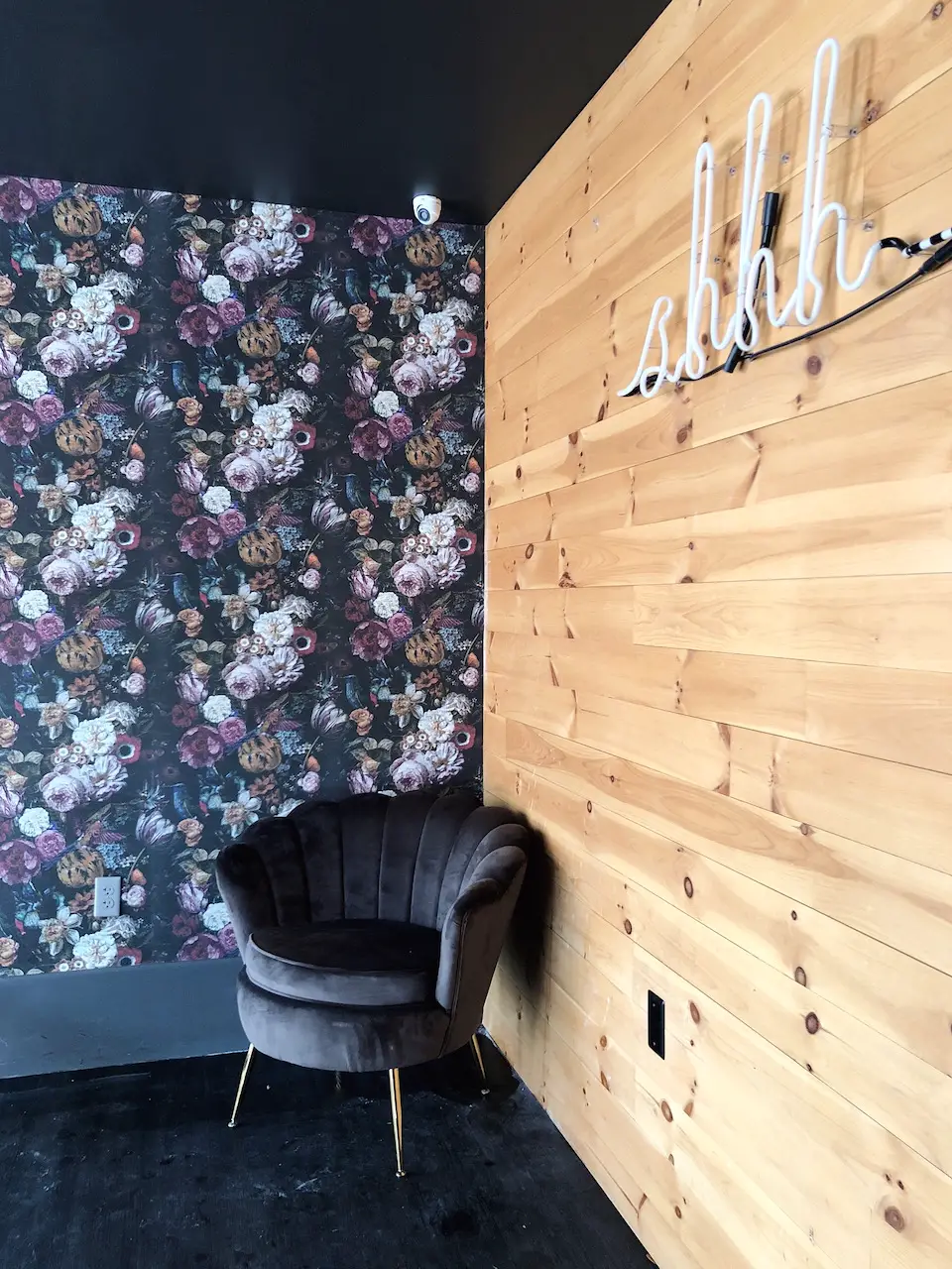 floral wallpaper with a velvet chair in the corner
